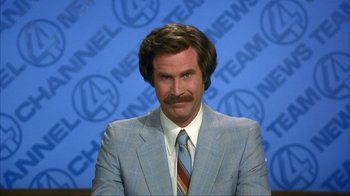 Movie still from “Anchorman: The Legend of Ron Burgundy” (2004), directed by Adam McKay – Anchorman actor will ferrell in front of a news room backdrop; Close Up shot, Low angle