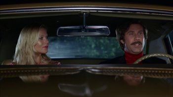 Movie still from “Anchorman: The Legend of Ron Burgundy” (2004), directed by Adam McKay – A man and a woman sitting in the back seat of a car; Medium shot, Low angle