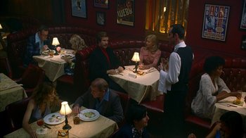 Movie still from “Anchorman: The Legend of Ron Burgundy” (2004), directed by Adam McKay – A group of people sitting at a table in a restaurant; Wide shot, High angle