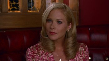 Movie still from “Anchorman: The Legend of Ron Burgundy” (2004), directed by Adam McKay – A woman sitting in a chair wearing a pink jacket; Close Up shot, Over the shoulder angle