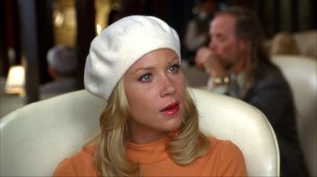 Movie still from “Anchorman: The Legend of Ron Burgundy” (2004), directed by Adam McKay – A woman wearing an orange shirt and a white hat; Close Up shot, Over the shoulder angle