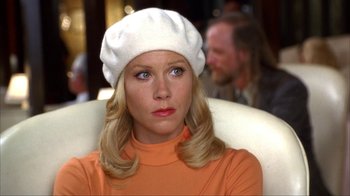 Movie still from “Anchorman: The Legend of Ron Burgundy” (2004), directed by Adam McKay – A woman wearing an orange shirt and a white hat; Close Up shot, Over the shoulder angle