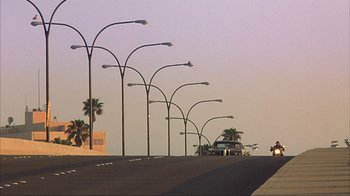 Movie still from “Anchorman: The Legend of Ron Burgundy” (2004), directed by Adam McKay – A street with a lot of street lights on the side of the road; Extreme Wide shot, Low angle