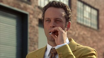 Movie still from “Anchorman: The Legend of Ron Burgundy” (2004), directed by Adam McKay – A person wearing a suit smoking a cigarette; Close Up shot, Low angle