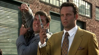 Movie still from “Anchorman: The Legend of Ron Burgundy” (2004), directed by Adam McKay – Two men in suits and ties holding a knife and a cell phone; Medium shot, High angle