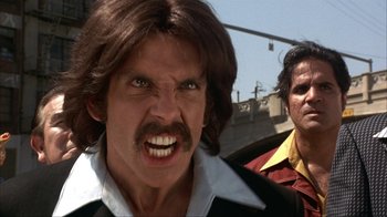 Movie still from “Anchorman: The Legend of Ron Burgundy” (2004), directed by Adam McKay – A man with long brown hair and a goatee is next to another man with long brown hair and a goatee; Close Up shot, Low angle
