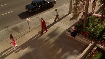 Movie still from “Anchorman: The Legend of Ron Burgundy” (2004), directed by Adam McKay – Two people walking down a sidewalk near a car; Extreme Wide shot, High angle