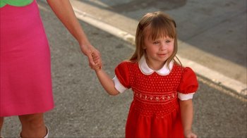 Movie still from “Anchorman: The Legend of Ron Burgundy” (2004), directed by Adam McKay – A little girl in a red dress holding her mother's hand; Close Up shot, Over the shoulder angle