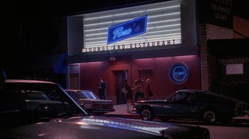Movie still from “Anchorman: The Legend of Ron Burgundy” (2004), directed by Adam McKay – A group of people standing in front of a building; Wide shot, High angle