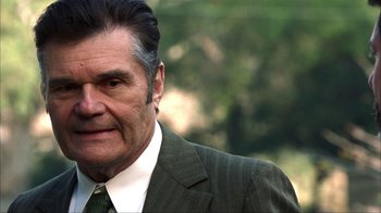 Movie still from “Anchorman: The Legend of Ron Burgundy” (2004), directed by Adam McKay – An older man wearing a suit and tie; Close Up shot, Over the shoulder angle