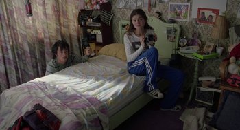 Movie still from “And Your Mother Too” (2001), directed by Alfonso Cuarón – Two young people sitting on a bed in a room; Medium shot, High angle