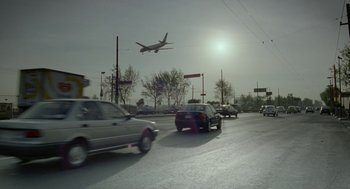Movie still from “And Your Mother Too” (2001), directed by Alfonso Cuarón – A large airplane flying over a busy city street; Extreme Wide shot, Low angle