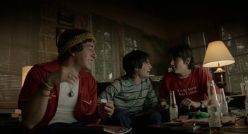 Movie still from “And Your Mother Too” (2001), directed by Alfonso Cuarón – A group of young men sitting on top of a couch; Medium shot, Low angle