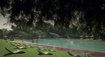 Movie still from “And Your Mother Too” (2001), directed by Alfonso Cuarón – Two people are standing in the grass near a swimming pool; Extreme Wide shot, High angle