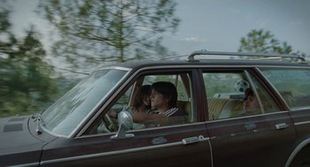 Movie still from “And Your Mother Too” (2001), directed by Alfonso Cuarón – Two people in a car kissing in the driver's seat of the car; Wide shot, Low angle