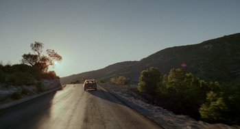 Movie still from “And Your Mother Too” (2001), directed by Alfonso Cuarón – A car driving down a road near some trees; Extreme Wide shot, Low angle
