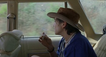 Movie still from “And Your Mother Too” (2001), directed by Alfonso Cuarón – A man sitting in a car smoking a cigarette; Close Up shot, Over the shoulder angle