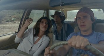 Movie still from “And Your Mother Too” (2001), directed by Alfonso Cuarón – A group of people riding in the back of a car; Medium shot, Low angle