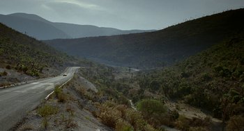 Movie still from “And Your Mother Too” (2001), directed by Alfonso Cuarón – A car driving down a road in the middle of a valley; Extreme Wide shot, High angle