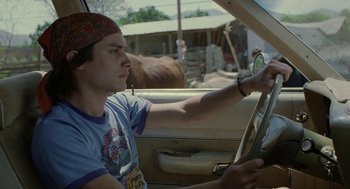 Movie still from “And Your Mother Too” (2001), directed by Alfonso Cuarón – A young man driving a car in a parking lot; Close Up shot, Low angle