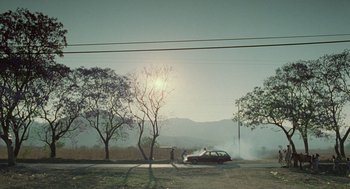 Movie still from “And Your Mother Too” (2001), directed by Alfonso Cuarón – A car on fire on the side of the road; Extreme Wide shot, Low angle