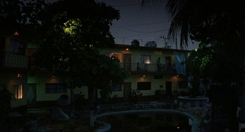 Movie still from “And Your Mother Too” (2001), directed by Alfonso Cuarón – A night time view of a building and a pond; Extreme Wide shot, Low angle