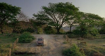 Movie still from “And Your Mother Too” (2001), directed by Alfonso Cuarón – A truck driving down a dirt road next to a tree; Extreme Wide shot, Low angle