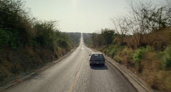 A car driving down the middle of a road