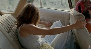Movie still from “And Your Mother Too” (2001), directed by Alfonso Cuarón – A woman sitting in the back seat of a car; Medium shot, High angle