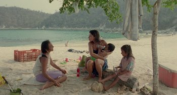 Movie still from “And Your Mother Too” (2001), directed by Alfonso Cuarón – A group of people sitting on the beach; Wide shot, High angle