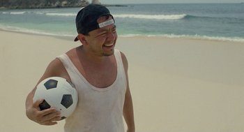 Movie still from “And Your Mother Too” (2001), directed by Alfonso Cuarón – A man holding a soccer ball on the beach; Medium shot, High angle