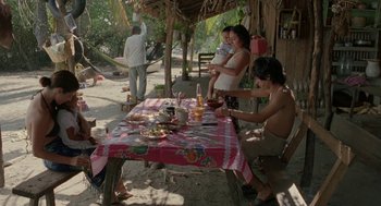 Movie still from “And Your Mother Too” (2001), directed by Alfonso Cuarón – A group of people sitting at a table with food on it; Wide shot, High angle