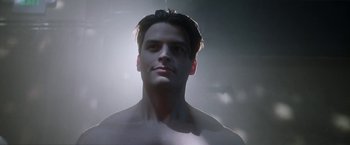 Movie still from “Angel of Anywhere” (2018), directed by James Kicklighter – A man with no shirt is looking at the camera; Close Up shot, Low angle