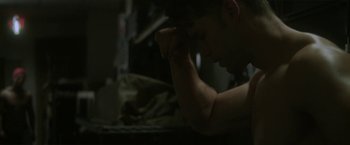 Movie still from “Angel of Anywhere” (2018), directed by James Kicklighter – A man sitting in front of a computer keyboard; Close Up shot, Low angle