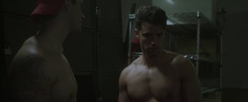 Movie still from “Angel of Anywhere” (2018), directed by James Kicklighter – A man standing next to another man in a room; Medium shot, Over the shoulder angle