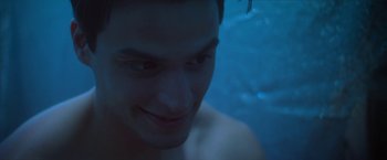 Movie still from “Angel of Anywhere” (2018), directed by James Kicklighter – A man's face in a swimming pool at night; Close Up shot, High angle