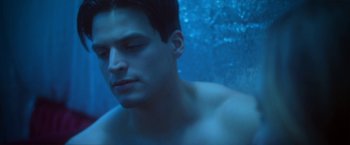 Movie still from “Angel of Anywhere” (2018), directed by James Kicklighter – A young man is swimming in a pool of blue water; Close Up shot, Low angle