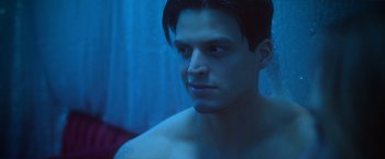 Movie still from “Angel of Anywhere” (2018), directed by James Kicklighter – A young man with no shirt is looking at the camera; Close Up shot, Low angle