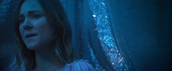 Movie still from “Angel of Anywhere” (2018), directed by James Kicklighter – A woman standing in front of a wall with blue lights; Close Up shot, Low angle
