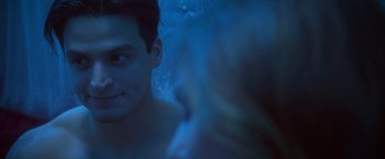 Movie still from “Angel of Anywhere” (2018), directed by James Kicklighter – A young man in a blue light looking into the camera; Close Up shot, Over the shoulder angle