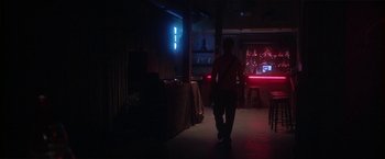 Movie still from “Angel of Anywhere” (2018), directed by James Kicklighter – A man walking down a hallway in a dark room; Wide shot, Low angle