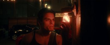 Movie still from “Angel of Anywhere” (2018), directed by James Kicklighter – A man looking at a light bulb in a dark room; Close Up shot, Low angle