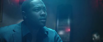 Movie still from “Angel of Anywhere” (2018), directed by James Kicklighter – A man in a black shirt is looking at the camera; Close Up shot, Low angle