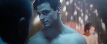 Movie still from “Angel of Anywhere” (2018), directed by James Kicklighter – A shirtless man with a blurry background; Close Up shot, Over the shoulder angle