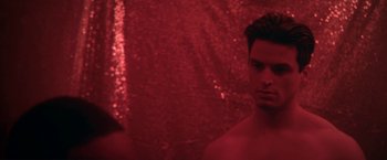 Movie still from “Angel of Anywhere” (2018), directed by James Kicklighter – A young man in a red room with red curtains; Close Up shot, Over the shoulder angle
