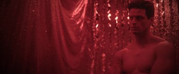 Movie still from “Angel of Anywhere” (2018), directed by James Kicklighter – A woman in a red dress standing in front of a red curtain; Close Up shot, Low angle