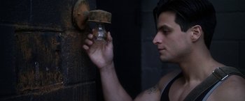 Movie still from “Angel of Anywhere” (2018), directed by James Kicklighter – A man holding onto a fire hydrant that is rusty; Close Up shot, Low angle