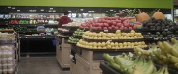 Movie still from “Angel of Anywhere” (2018), directed by James Kicklighter – Many different types of fruits on the shelves; Extreme Wide shot, Low angle