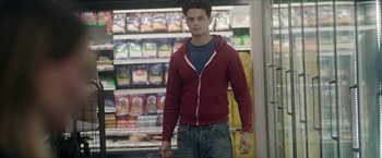 Movie still from “Angel of Anywhere” (2018), directed by James Kicklighter – A man in a red jacket is standing in front of a store; Medium shot, Over the shoulder angle