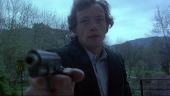 Movie still from “Angst” (1983), directed by Gerald Kargl – A man holding a gun pointed at the camera; Close Up shot, Low angle
